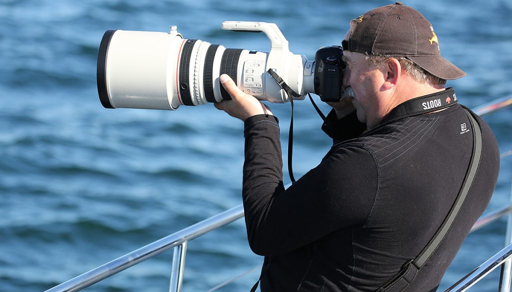 An Eagle Wing Tours photographer aims his large lens at a whale